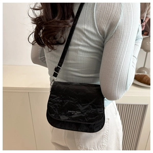 Vue détaillée du sac besace noir avec texture froissée et logo imprimé en blanc