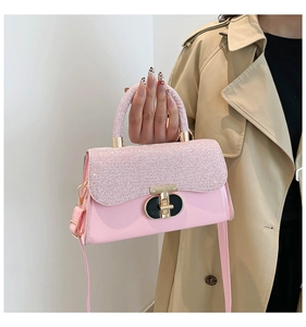 Detail of pink sequin handbag with gold twist lock and smooth leather base