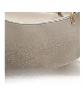Close-up of beige crocodile pattern faux leather and golden metal zipper detail