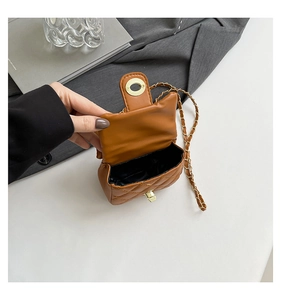 Interior view of brown quilted leather chain bag with black lining and metal turn-lock