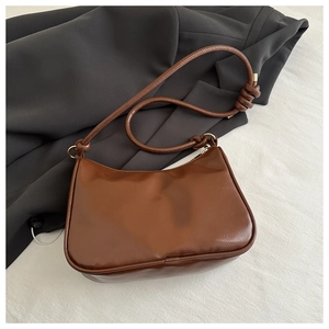 Detail shot of the vintage brown hobo bag with unique knot decoration on the shoulder strap
