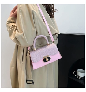Detailed side view of pink crossbody bag with purple glitter flap and gold rotary buckle