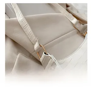 Detail of white crocodile pattern texture with golden metal ring and shoulder strap link