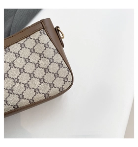 Detailed macro view of monogram canvas texture and premium brown leather trim on bag