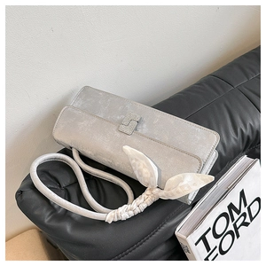 Detail of silver rectangular evening bag with crystal buckle and silk knot handle