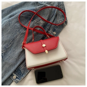 Détail du sac à bandoulière contrasté rouge et blanc avec boucle dorée et texture en cuir PU