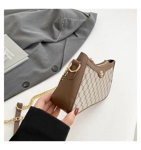 Detail of vintage half-moon crossbody bag with monogram fabric and gold chain strap