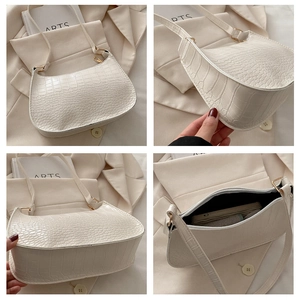 Detailed views of a white crocodile embossed hobo bag with zip closure and strap