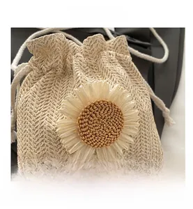 Detailed view of woven straw bucket bag with sunflower detail and drawstring closure
