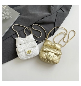 Detail of mini quilted crossbody bags with bow accent and gold chain straps