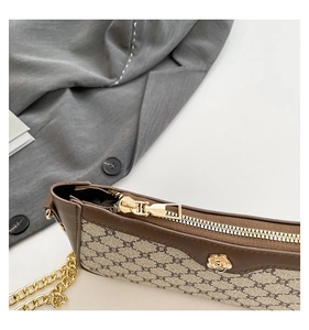 Detail of the golden zipper and luxury floral metallic ornament on vintage monogram bag
