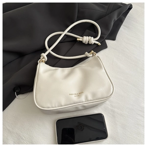 Detail of cream PU leather hobo bag with knotted strap and gold foil lettering