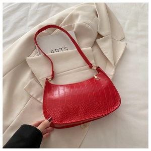 Detail of red croc-embossed crescent underarm bag with gold metal buckle and zipper