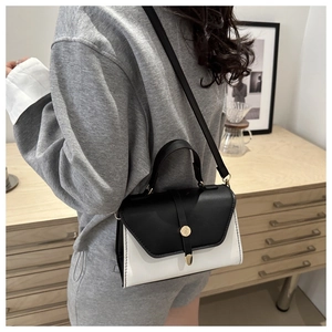 Détail d'un sac à main minimaliste en cuir bicolore noir et blanc avec boucle dorée