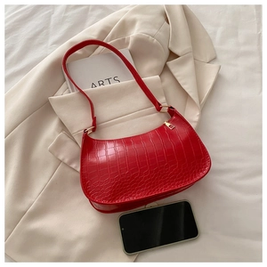 Detail of red crocodile texture on hobo shoulder bag with elegant gold zipper and hardware