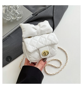 Close-up of white quilted mini bag with leather bow and gold twist-lock detail
