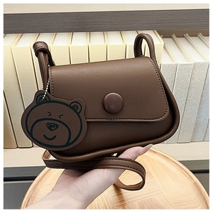 Detailed view of brown PU leather small square bag with cute bear charm and flap closure