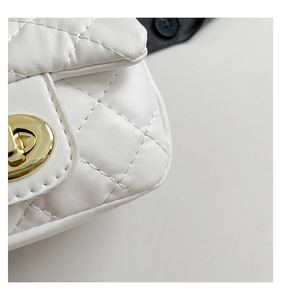 Detail of white quilted leather texture with gold metal twist lock and stitching