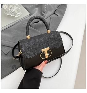 Detailed shot of a black sequin crossbody bag featuring a golden metal twist lock clasp