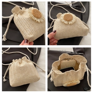 Detail of woven straw bucket bag with 3D sunflower decor and cotton rope strap