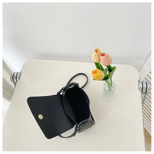 Detail view of the black crossbody bag showing magnetic flap closure and interior space