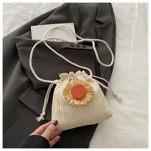 Détail du sac seau en paille avec tournesol 3D et texture tissée blanche en V