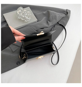 Interior view showing spacious compartment of black leather bag with gold twist lock