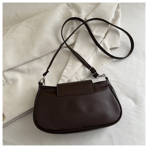 Detail of a vintage chocolate brown crossbody bag with matte PU texture on white fabric
