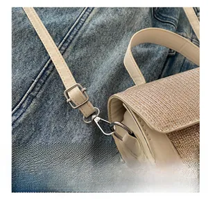 Macro shot of silver swivel hook hardware on cream leather bag with champagne sequins