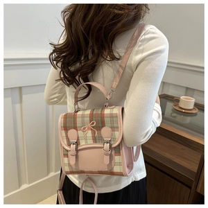 Detailed view of a mini plaid backpack with a pink bow and retro checkered pattern
