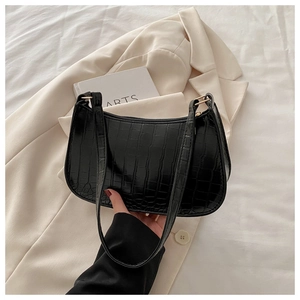 Close-up of black crocodile embossed faux leather shoulder bag with sleek zip closure