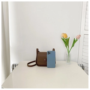 Brown minimalist shoulder bag shown next to a smartphone for size comparison