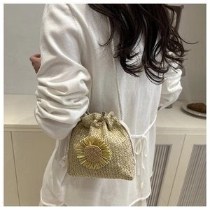 Detail view of woven straw bucket bag with sunflower accent and drawstring closure