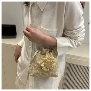 Detail of woven bucket bag featuring sunflower decor and drawstring closure
