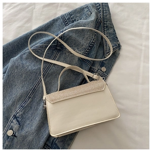 Close-up of the silver glitter sequin flap on the beige leather square crossbody bag