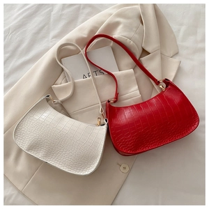Detail of red and white faux leather underarm bags with premium crocodile texture