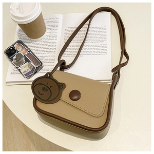 Detail of Korean style square bag with contrast paneling and cute bear charm