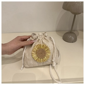 Dettaglio borsa a secchiello in paglia con grande girasole giallo e chiusura a coulisse