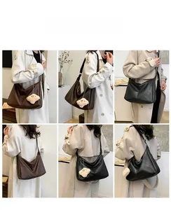 Detail view of large minimalist shoulder bags in black and brown with plush charm