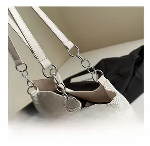 Detail of cream woven tote bag with silver metal chain link and textured fabric