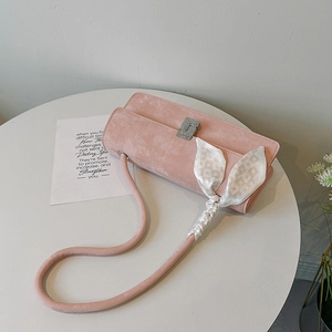 Pink suede shoulder bag with silk scarf and crystal buckle shown from a 45-degree angle