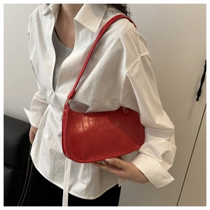 Detail of red crocodile pattern underarm bag featuring elegant gold zipper and PU texture
