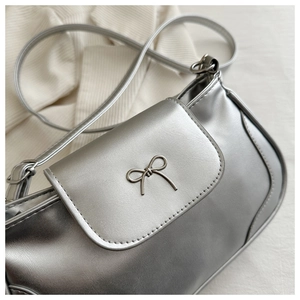 Close-up of metallic silver bag with grey metal bow buckle and smooth PU leather texture