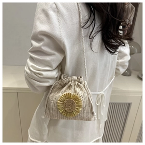 Detail of straw bucket bag with sunflower decor and drawstring closure for summer beach