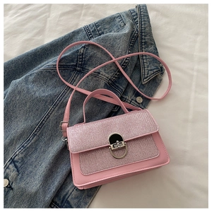 Detail of pink sequin patchwork crossbody bag featuring an oval silver swivel lock