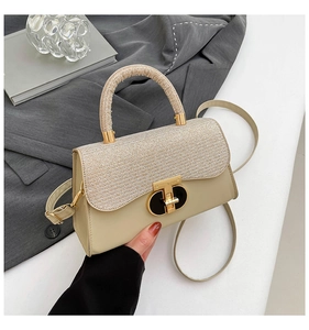Detail of elegant beige crossbody bag with mixed textures and gold oval twist-lock closure