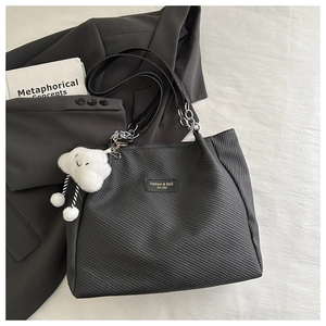 Détail du sac cabas noir avec bandoulière en chaîne et breloque nuage en peluche