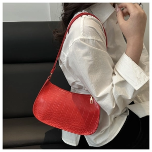 Detail of red crocodile pattern PU leather underarm bag with gold trapezoid zipper