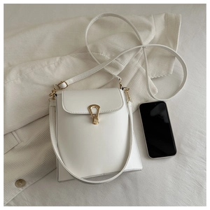 Vue de dessus d'un sac seau blanc avec boucle fer à cheval dorée et smartphone