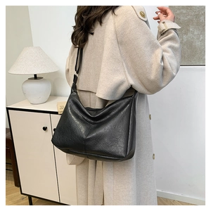 Detailed view of black large capacity tote bag with soft texture on a model shoulder